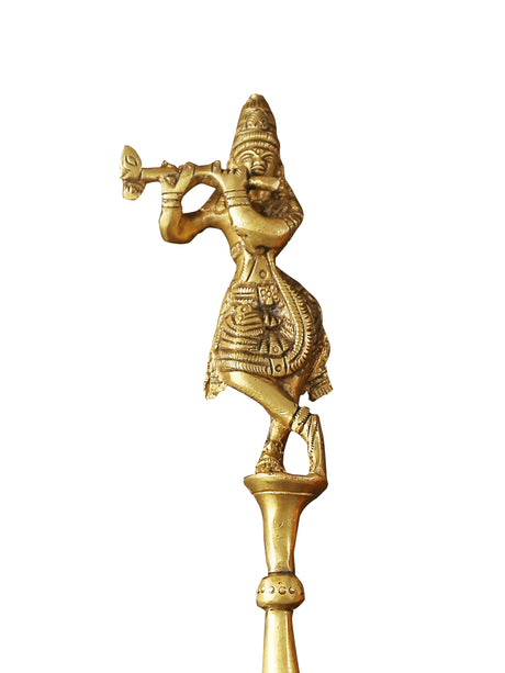 Handcrafted brass spoon featuring detailed Krishna idol design on white background.