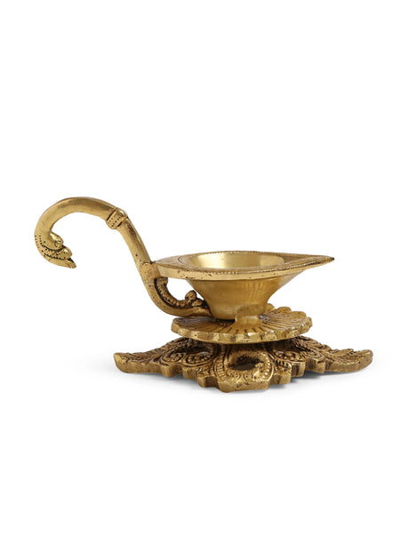 Handcrafted brass diya with a beautifully detailed base and curved handle, ideal for festive decor.