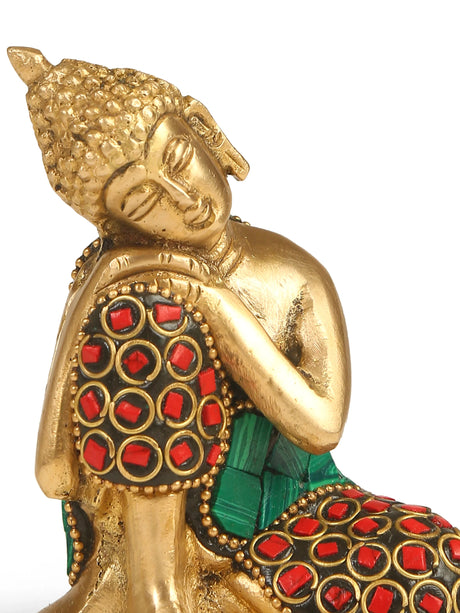 Brass Buddha statue with intricate stone work in turquoise, red, and blue, representing serenity and spiritual calm.
