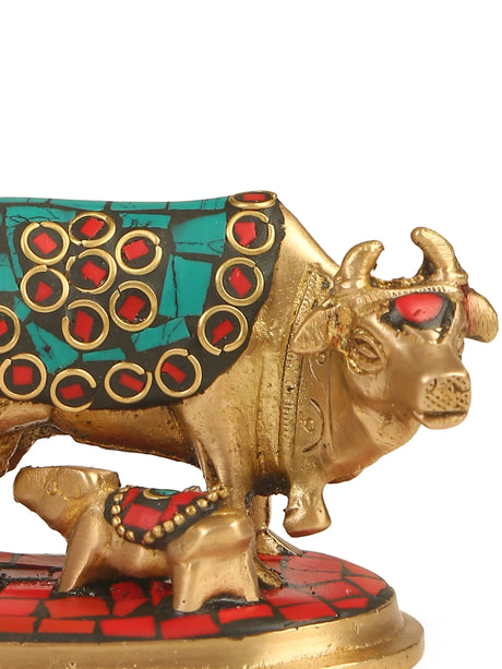 Kamdhenu brass statue with calf, showcasing intricate stone detailing in turquoise, red, and gold.