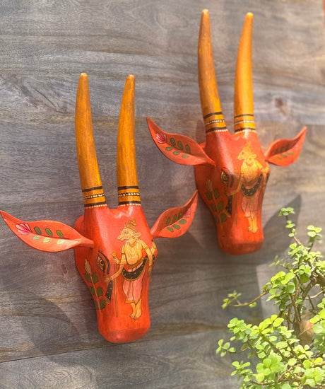 Decorative wooden cow face with vibrant hand-painted details for wall mounting.