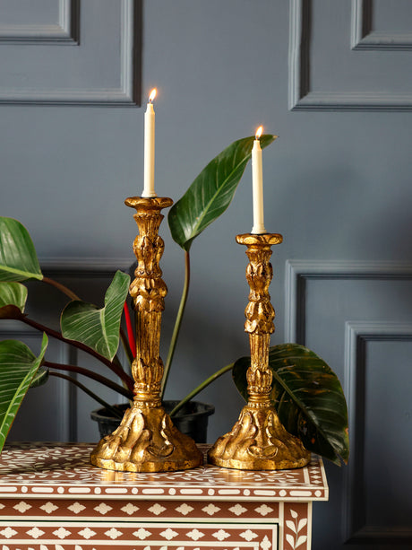 Handcrafted radiant gold foil candle holders with red-based antique finish.