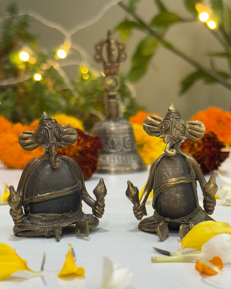 Vintage style metal Ganesha figurines in musical pose, spiritual home décor accent with floral backdrop.