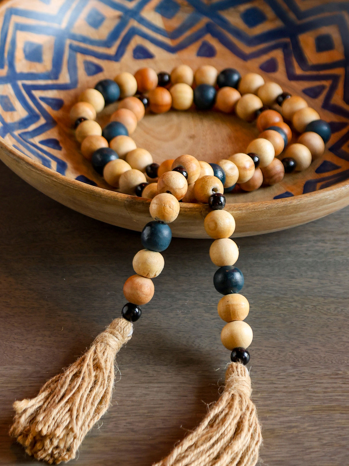 Natural wood bead decor string arranged in decorative bowl.