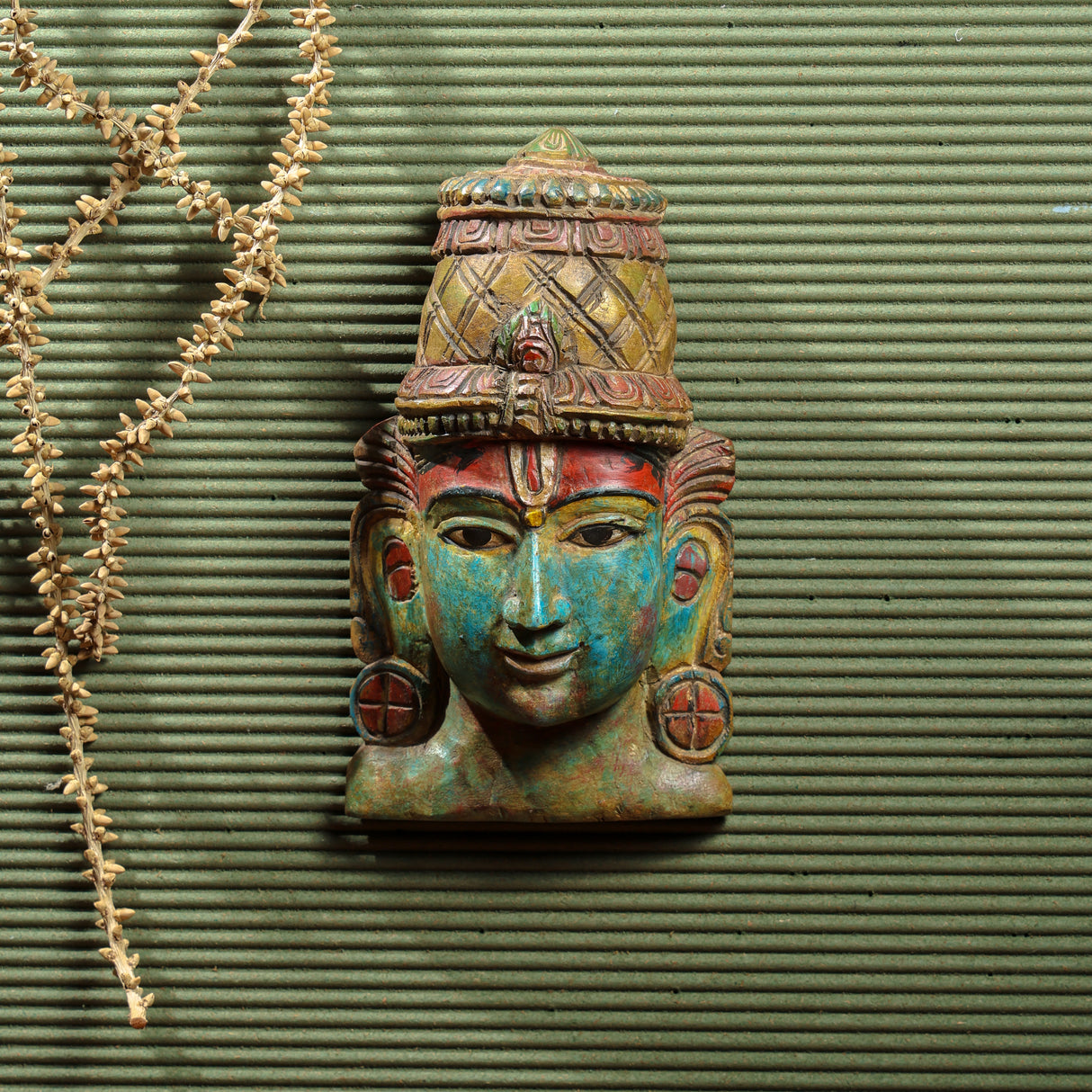 Hand-carved Vishnu mask with detailed artwork and serene expression, crafted from Vaaghai wood in assorted colors.