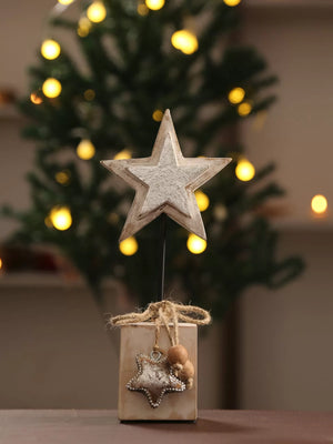 Wooden star with silver foiling table decor on iron stand in white finish.