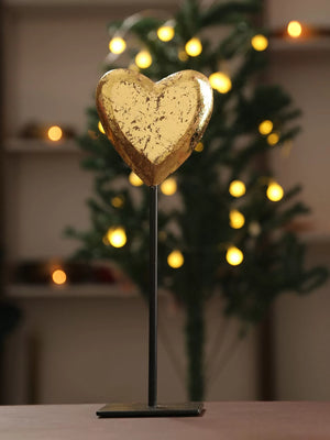Distress finish gold foiled heart table decor in antique gold on black iron stand