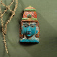 Close-up of a handcrafted Vishnu mask, symbolizing divine protection, made from Vaaghai wood in intricate detail.